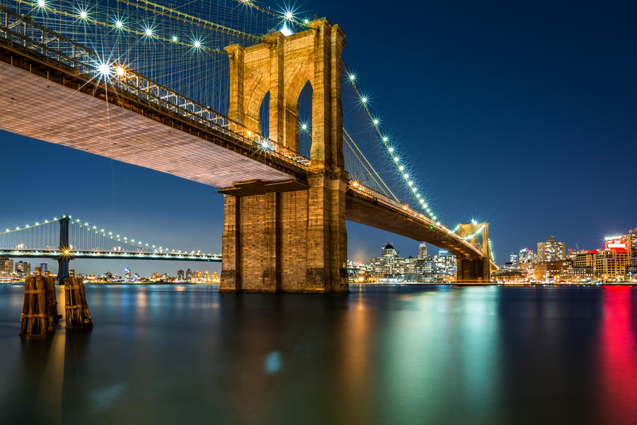 Illuminated Brooklyn Bridge by night as viewed from the Manhattan side - very long exposure for a perfectly smooth water