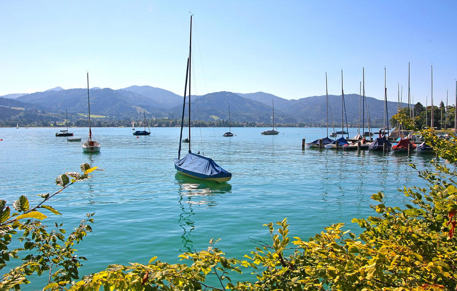 tegernsee lake shore with moored sailing boats, tranquil bavarian scenery
