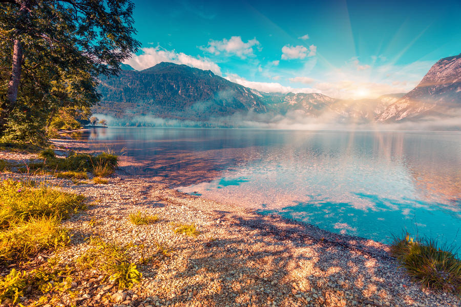 Foggy summer morning on the Bohinj lake. Triglav national park, Slovenia, Julian Alps, Europe. Instagram toning.