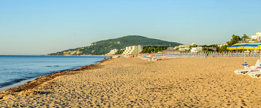 The Black Sea shore from Albena, Bulgaria with golden sands, blue fresh water, sunbeds and umbrellas near beach hotels.