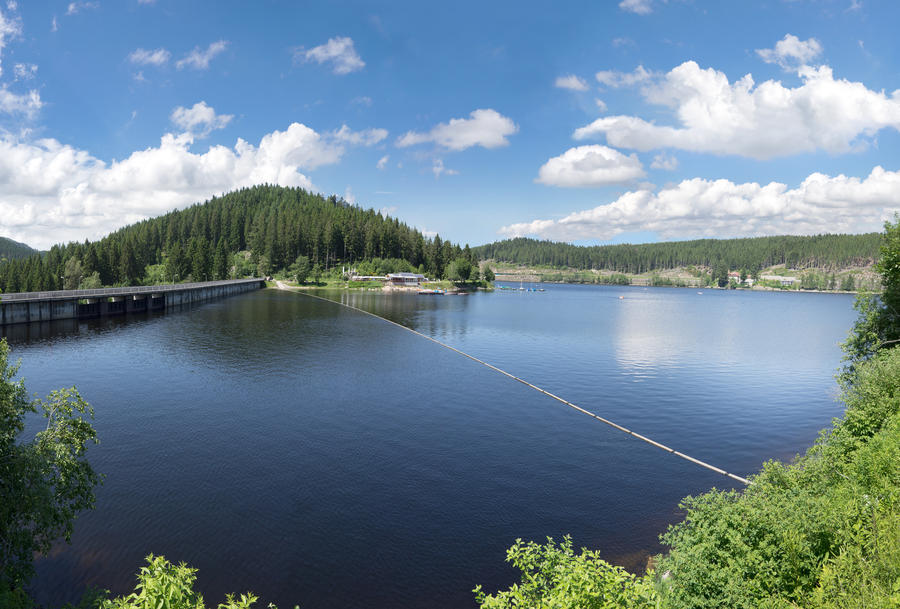 Lake Schluchsee with dam in the Black Forest, Germany, on a sunny summer day with blue and white sky