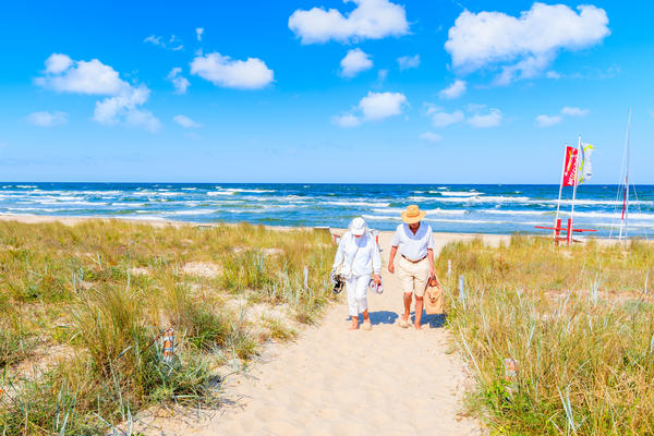BAABE, RUEGEN ISLAND - MAY 31, 2018: Couple of people walking from beach in Baabe summer resort among sand dunes, Baltic Sea, Germany. Ruegen is popular tourist destination due to its sandy beaches.