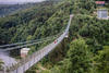 people walk through a suspension bridge over the river. Rappbode Dam, Rappbode-Talsperre in Elbingerode, Harz , Germany.
