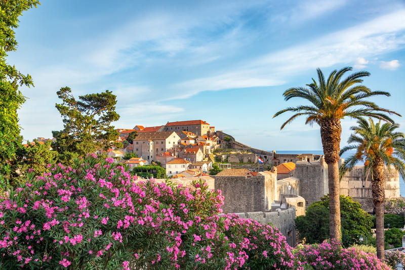 View of flowers, palm trees, and the historic center of Dubrovnik, Croatia