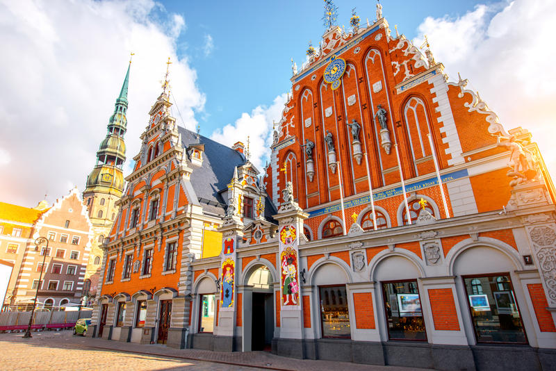 View on the central square with famous houses of Blackheads and cathedral tower in Riga city, Latvia