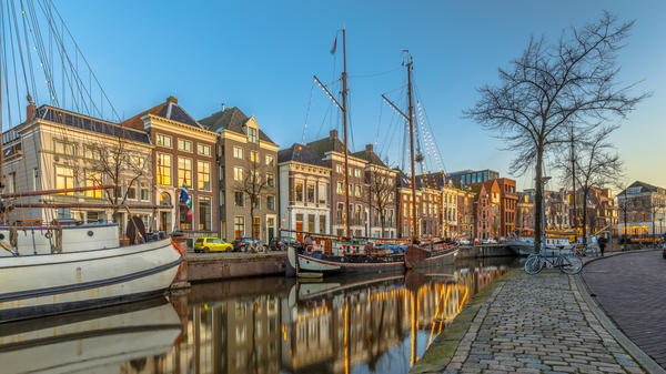 Historic buildings on Hoge der Aa Quay with ship in Groningen city centre at sunset, Netherlands
