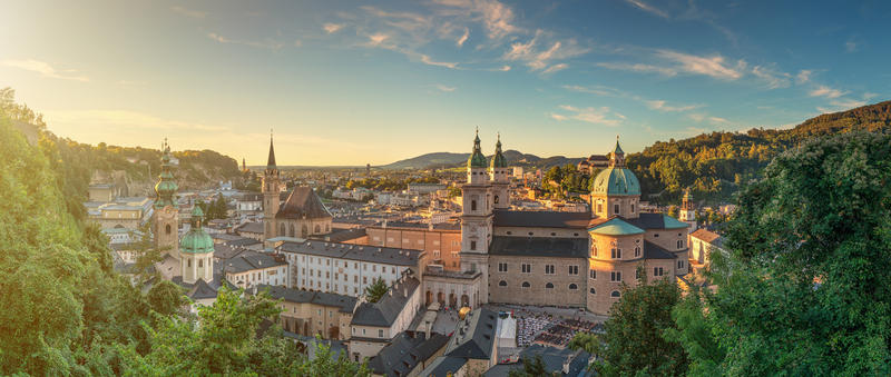 Panoramic view of the historic city of Salzburg with beautiful Salzach river from famous Hohensalzburg Fortress in golden evening light at sunset in summer, Salzburger Land, Austria