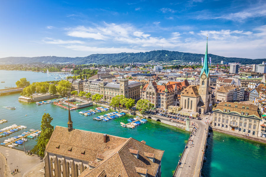Aerial view of historic Zurich city center with famous Fraumunster Church and river Limmat at Lake Zurich from Grossmunster Church on a sunny day with clouds in summer, Canton of Zurich, Switzerland