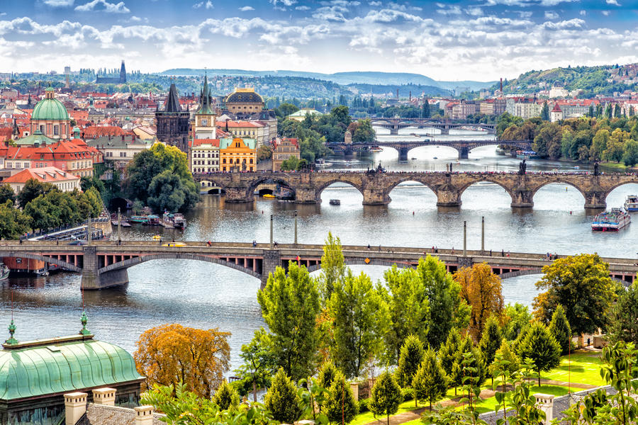 Scenic view of bridges on the Vltava river and of the historical center of Prague: buildings and landmarks of old town with red rooftops and multi-coloured walls.