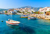 Fishing boats in Kokkari bay with colourful houses in background, Samos island, Greece