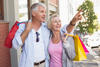 Happy mature couple walking with their shopping purchases on a sunny day