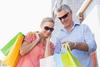 Happy senior couple shopping in the city on a sunny day