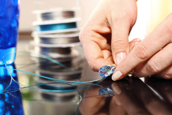 Jewelry, silver earring with crystals.Woman performs necklace with Swarovski crystals