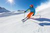 Skier skiing downhill during sunny day in high mountains