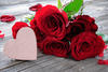 Red roses and heart on wooden background. Valentines day background
